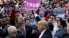 Republican presidential candidate Donald Trump holds up a sign handed to him by a supporter after speaking at a campaign rally in Bethpage, New York, April 6, 2016. 