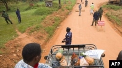Supporters of the opposition leader Robert Kyagulanyi, also known as Bobi Wine, are blocked by police officers at checkpoint on a street leading to Kyagulanyi's house, as they bring food to deliver in Magere, Uganda, Jan. 21, 2021.