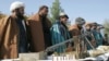 FILE - Taliban fighters line up as they hand over their weapons to join the peace process in Herat, Afghanistan, Nov. 3, 2012.
