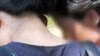 Two North Koreans turn away as a group of journalists and refugee activists attempt to talk to them