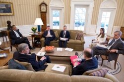 Suratdagi yagona ayol, Avril Heynz, Obama prezidentligi davrida Oq uydagi eng muhim rasmiylardan biri edi