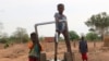 Children play on a water pump in an internally displaced camp in Gaoa, Burkina Faso, April 22, 2021.