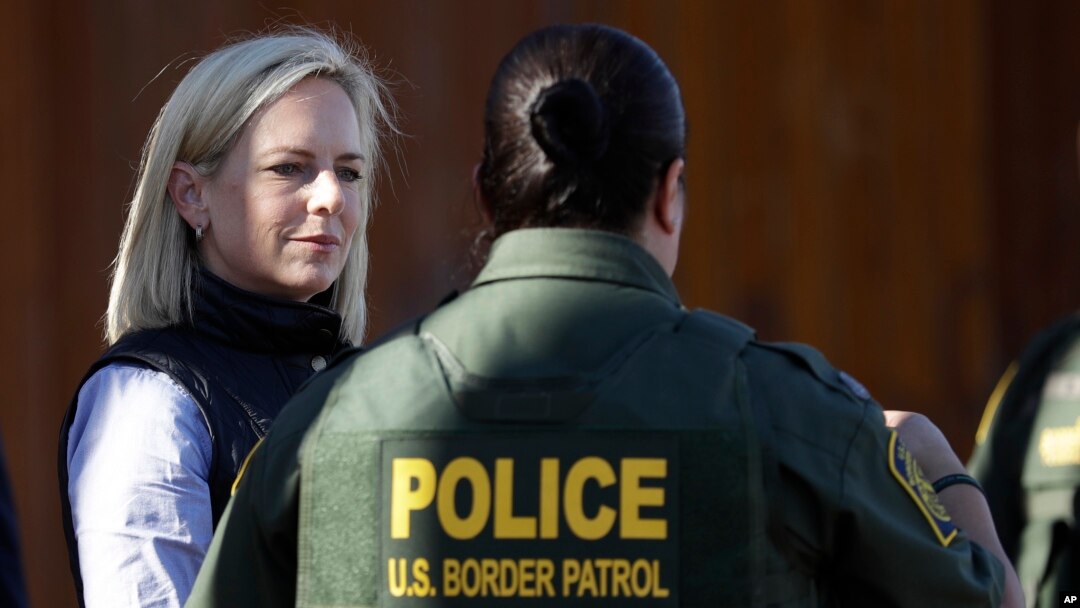 FILE - U.S. Department of Homeland Security Secretary Kirstjen Nielsen, left, speaks with Border Patrol agents near a newly fortified border wall structure, Oct. 26, 2018, in Calexico, Calif. 