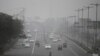 Vehicles move through morning smog on the last day of a two-week experiment to reduce the number of cars to fight pollution in New Delhi, India, Jan. 15, 2016. 
