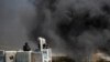 An Israeli border policeman aims his weapon toward Palestinian protesters during clashes at a protest against the Israeli offensive in Gaza, outside Israel's Ofer military prison near the West Bank city of Ramallah, July 18, 2014. 