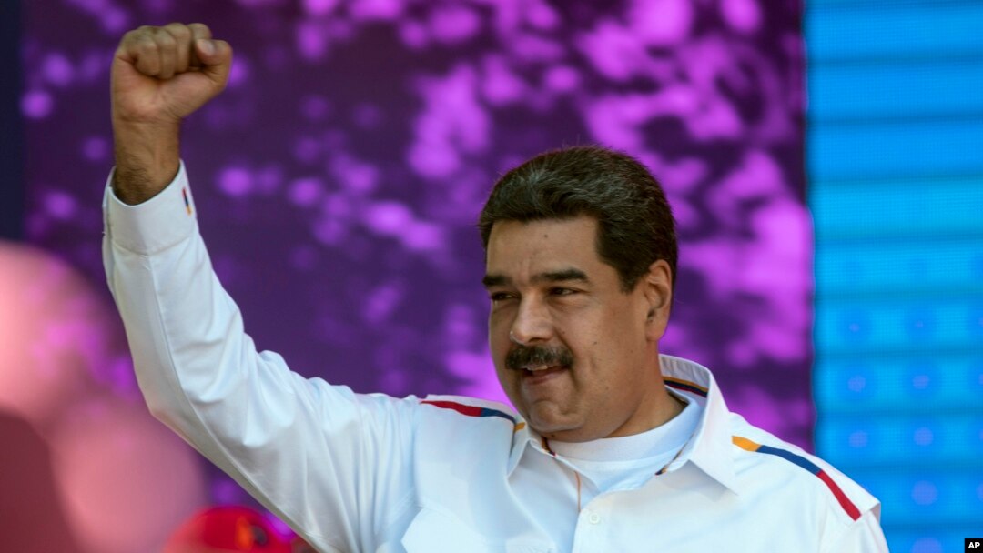 FILE - Venezuela's President Nicolas Maduro pumps his fist during a pro-government demonstration in Caracas, Venezuela, Feb. 12, 2019. 