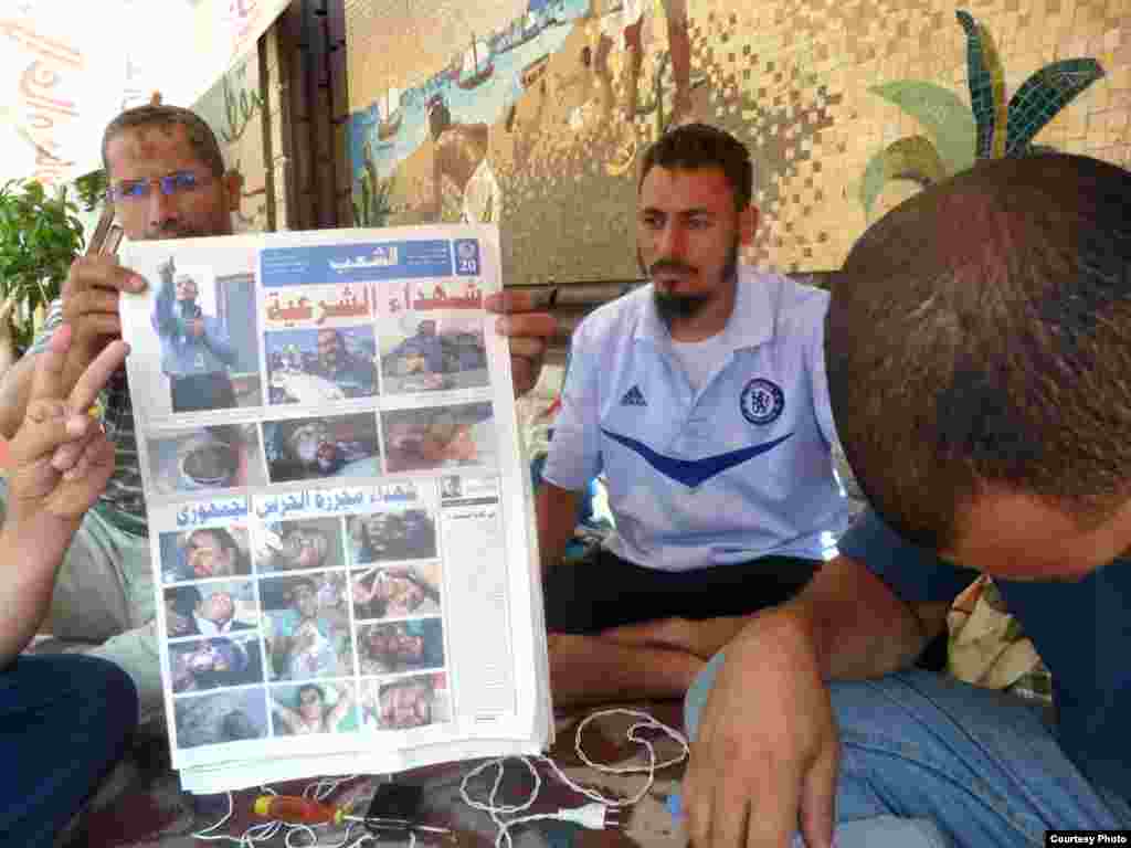 Muslim Brotherhood doctors hold up newspaper with photos of their supporters killed in a confrontation with the Egyptian military on July 8. Photo: VOA/Sharon Behn&nbsp;