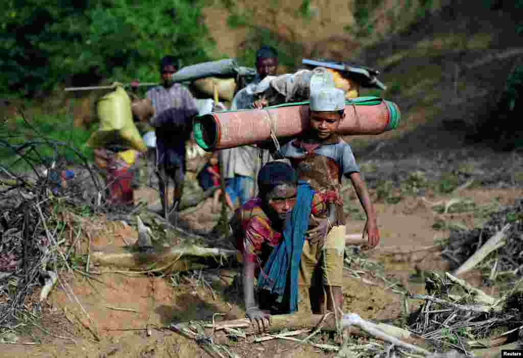 Rohingya refugees walk on a muddy path after crossing the Bangladesh-Myanmar border in Cox's Bazar, Bangladesh.