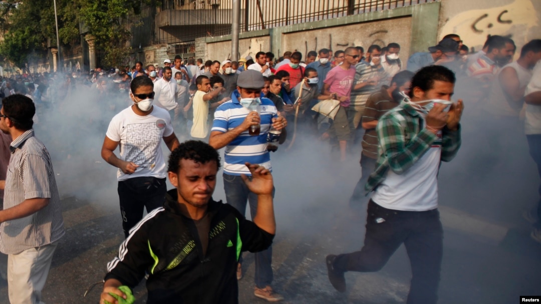 Anti-government and supporters of ousted Egyptian President Mohamed Morsi run after riot police released tear gas along a road at Kornish El Nile, which leads to Tahrir Square, Cairo, October 6, 2013. 