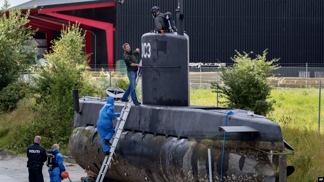 FILE - Police technicians board the amateur-built submarine UC3 Nautilus on a pier in Copenhagen harbour, Denmark, Aug. 13, 2017, to conduct forensic probes in connection with a murder investigation. 