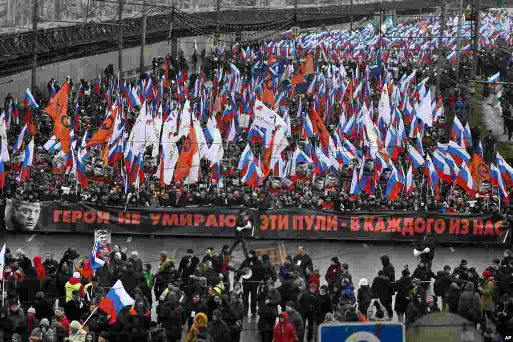 People carry a huge banner reading "Those bullets for everyone of us, heroes never die!" as they march in memory of opposition leader Boris Nemtsov who was gunned down on Friday near the Kremlin, in Moscow, Russia, March 1, 2015. 