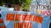 FILE - Protesters display placards in front of the Chinese Consulate to protest China's alleged continuing "militarization" of the disputed islands off the South China Sea including a plan to build a monitoring station on Scarborough Shoal, March 24, 2017. W.P.S. in the placard stands for West Philippine Sea.