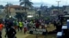 FILE - Hundreds of youths run through the streets of Ekona, cheering, waving palm fronds, and holding signs demanding independence in this image taken from video, Sept. 22, 2017. 