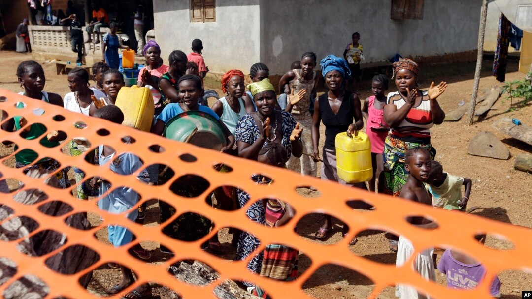 FILE - People celebrate as they are released from Ebola quarantine in the village of Massessehbeh on the outskirts of Freetown, Sierra Leone, Aug. 14, 2015.