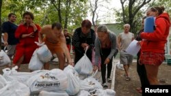 Біженці з Донеччини отримують їжу на околиці Маріуполя, 10 вересня 2014 р. 