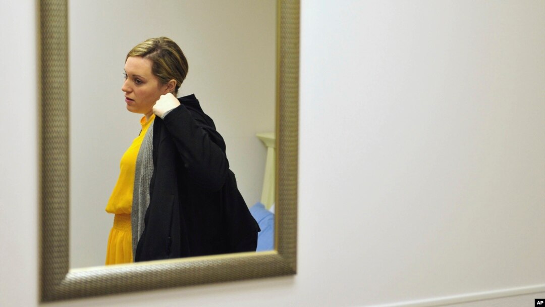 Heidi Wyandt, 27, puts on her coat to leave the Altoona Center for Clinical Research in Altoona, Pennsylvania., March 29, 2017, where she is helping test an experimental non-opioid pain medication for chronic back pain related to a work related injury she received in 2014.
