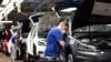 FILE - A worker wears a protective mask at the Volkswagen assembly line after VW re-started Europe's largest car factory after a coronavirus shutdown, in Wolfsburg, Germany, April 27, 2020.
