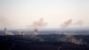 FILE - Smoke and explosions from the fighting between forces loyal to Syrian President Bashar Assad and rebels rise in the village of Jubata al-Khashab as seen from the Israeli-controlled Golan Heights.
