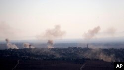 FILE - Smoke and explosions from the fighting between forces loyal to Syrian President Bashar Assad and rebels rise in the village of Jubata al-Khashab as seen from the Israeli-controlled Golan Heights.