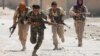 Kurdish fighters from the People's Protection Units (YPG) run across a street in Raqqa, Syria, July 3, 2017. 
