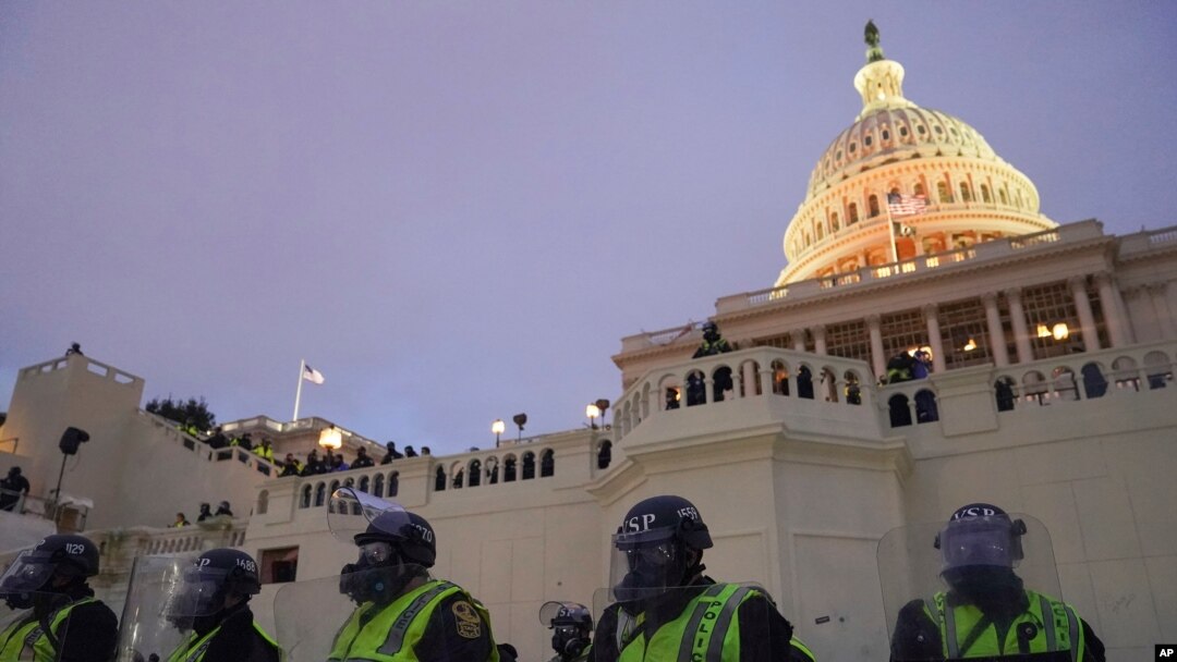 FILE - Police form a line to guard the Capitol after rioters stormed the Capitol, in Washington, Jan. 6, 2021.