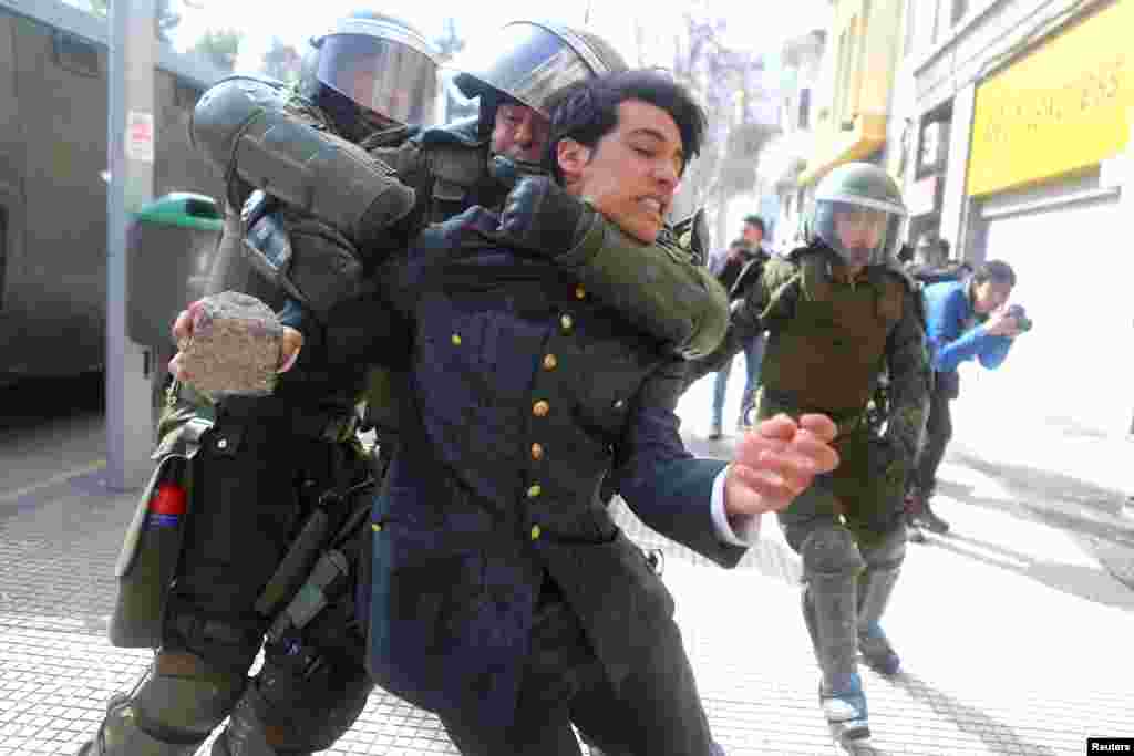 A demonstrator is detained during a rally to demand changes in the education system in Santiago, Chile.