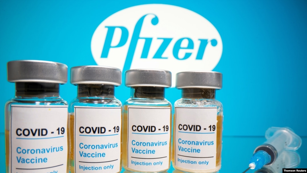 FILE PHOTO: Vials and medical syringe are seen in front of Pfizer logo in this illustration, Nov. 9, 2020. 