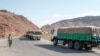 FILE - A man walks next to a convoy of trucks on their way to Tigray in the village of Erebti, Ethiopia, June 9, 2022.