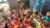 Younger children learn outside the bus that serves as a mobile school in New Delhi, India. (Anjana Pasricha/VOA)
