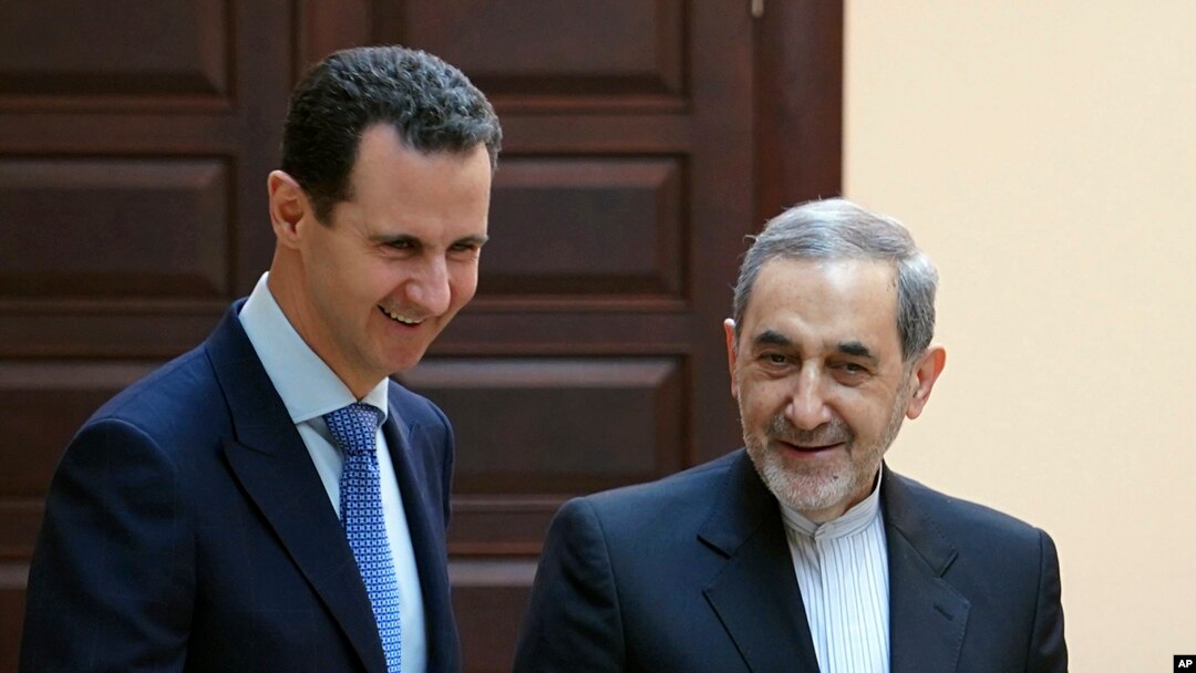 FILE - In this photo released by the Syrian official news agency SANA, Syrian president Bashar Assad, left, meets with Ali Akbar Velayati, an adviser to Iran's Supreme Leader Ayatollah Ali Khamenei, in Damascus, April 12, 2018.