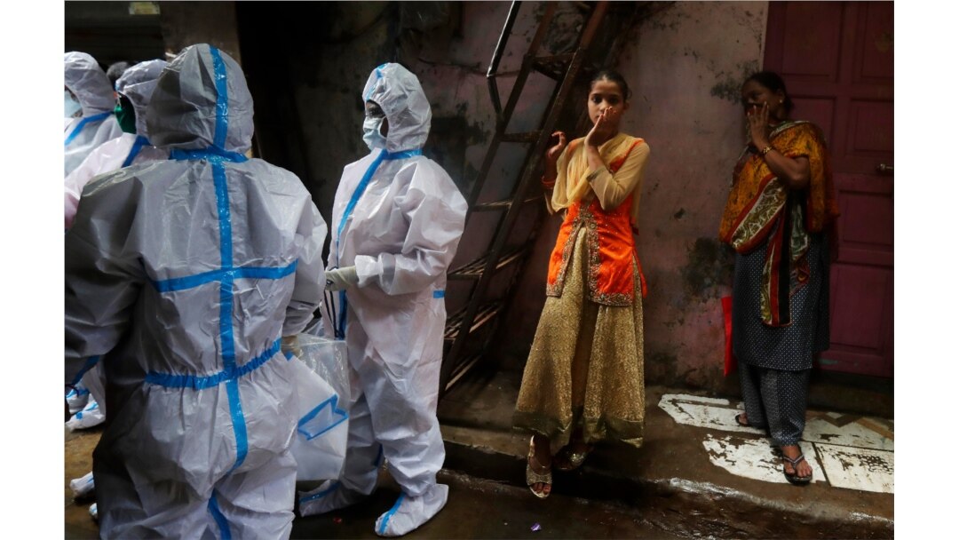 FILE - Health workers screen residents for COVID-19 symptoms at Dharavi, one of Asia's largest slums, in Mumbai, India, Aug. 3, 2020.