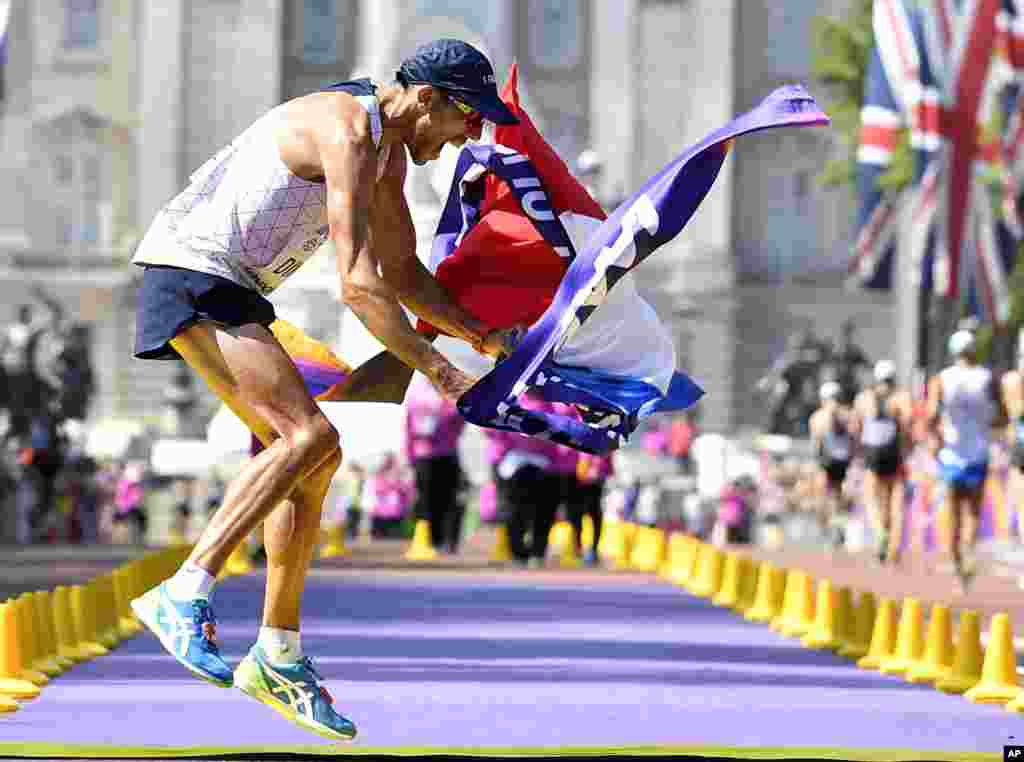 France&#39;s Yohann Diniz celebrates after crossing the line to win the gold medal in the men&#39;s 50-kilometer race walk during the World Athletics Championships in London.