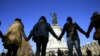 FILE - People hold hands to form a human solidarity chain near the site of the attack at the Bataclan concert hall in Paris, Nov. 15, 2015. 