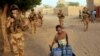 French soldiers patrolling the streets of Gao walk past a boy carrying canisters on Dec. 4, 2021.