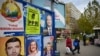 FILE - Pedestrians pass by electoral posters with candidates for the presidential and parliamentary elections in Bucharest, Nov. 22, 2024. Romania's constitutional court announced on Dec. 6, 2024, that it was canceling the presidential election.