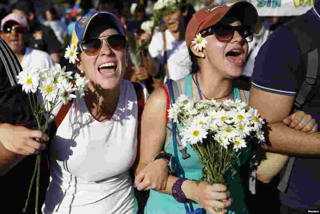 Apoiantes do líder da oposição, Leopoldo Lopez, marcham com flores numa manifestação pela paz em Caracas, Fev. 20, 2014.