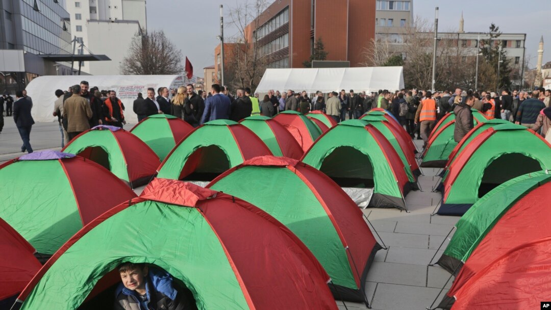 A child plays inside a tent set up by Kosovo opposition supporters in front of the main governing building in Kosovo's capital Pristina, Feb. 23, 2016.