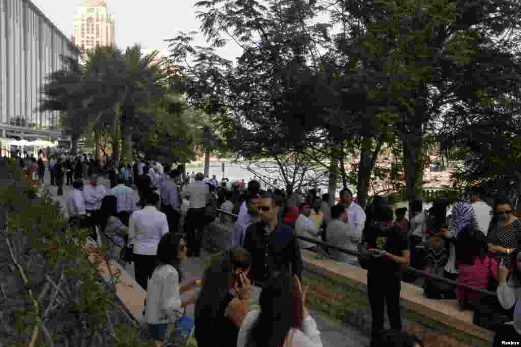 People wait outside after evacuating offices in Dubai Media City following tremors in Dubai, April 16, 2013. 