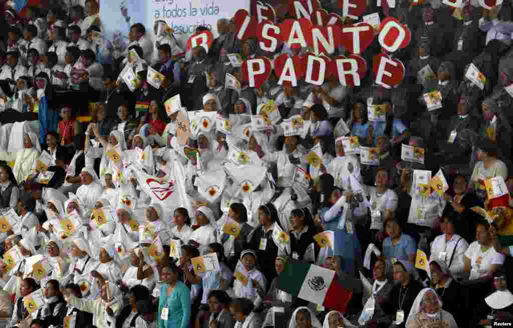 Nuns hold signs reading 'Holy Father' as they wait for Pope Francis at a meeting with priests and nuns in Don Bosco school, in Santa Cruz, July 9, 2015.