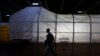 FILE - A U.S. marine officer walks past the Field Deployable Hidrolysis System (FDHS) of the U.S. MV Cape Ray ship docked at the naval airbase in Rota, near Cadiz, southern Spain.