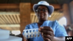 Profissional de saúde segura amostra das vacinas contra a cólera durante o lançamento de uma campanha para imunizar as pessoas com uma vacina contra a cólera nas zonas afectadas, na Policlínica de Kuwadzana, Harare, 29 de janeiro de 2024. (Photo by Jekesai NJIKIZANA / AFP)
