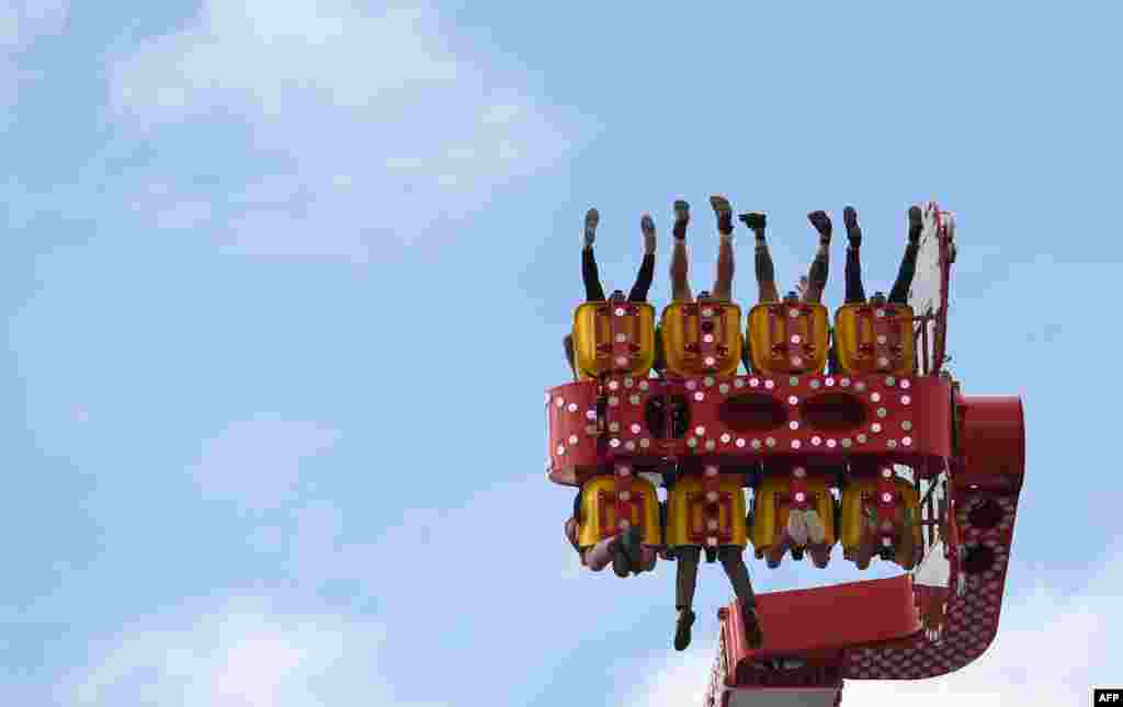 People sit in a fairground ride at the 184th Oktoberfest, Munich&#39;s annual beer festival in southern Germany.
