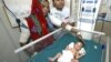 An Indian mother, left, looks at her baby girl, born prematurely, at Rajasthan Hospital's neo-natal intensive care unit in Ahmadabad, India, Feb. 28, 2008.