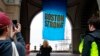 People photograph a banner reading "Boston Strong" as it hangs at Rowes Wharf on the first anniversary of the Boston Marathon bombings, Tuesday, April 15, 2014, in Boston. (AP Photo/Bill Sikes)
