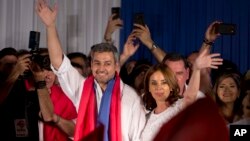 Paraguay's President Elect Mario Abdo Benitez. left, of Colorado Party, and his wife Silvana Lopez Moreira wave at supporters during celebrations at the party headquarter's in Asuncion, Paraguay, Sunday, April 22, 2018. 