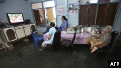 Một gia đình ngồi xem TV trong căn nhà bị ngập ở Bangkok, Thái Lan, ngày 3/10/2011