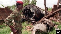 FILE - A Rwanda Patriotic Front (RPF) rebel walks by the the site of a April 6 plane crash which killed Rwanda's President Juvenal Habyarimana in this May 23, 1994 file photo in Kigali. 