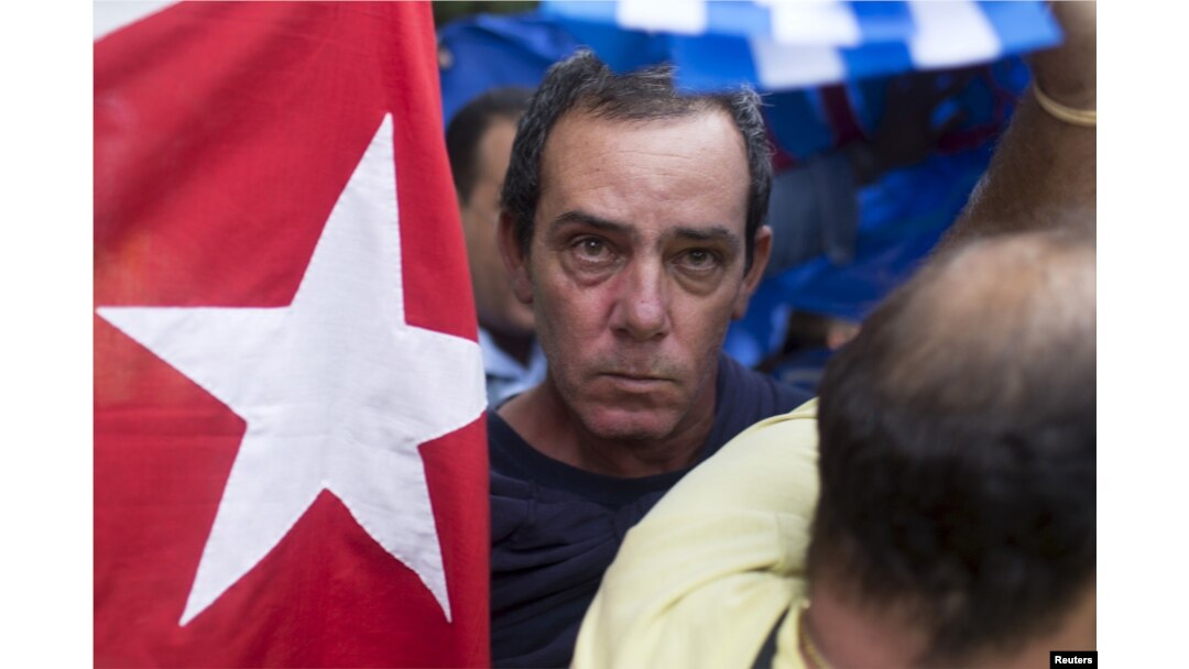 A supporter of the Ladies in White dissident group looks on as he is detained by Cuban security personnel during a protest on International Human Rights Day, Havana, December 10, 2015.