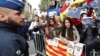 Demonstrators wave banners and flags as sacked Catalan leader Carles Puigdemont leaves a news conference at the Press Club Brussels Europe in Brussels, Belgium, Oct. 31, 2017. 