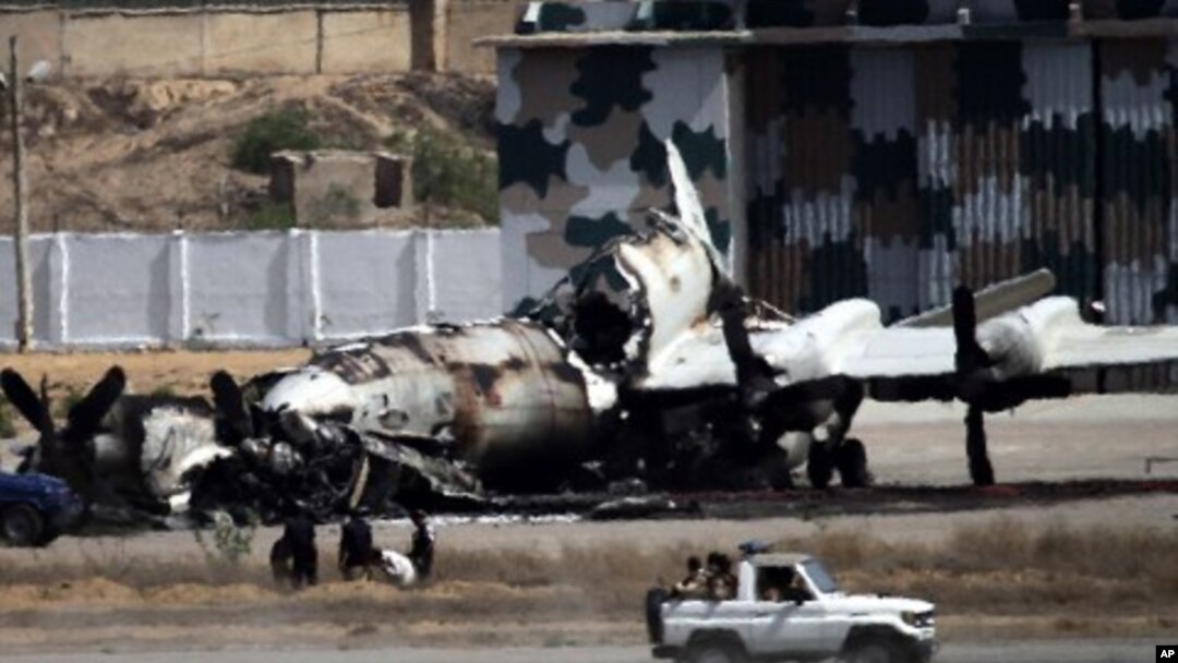 Pakistani troops drive past a wreckage of a gutted aircraft at Pakistan Navy base in Karachi, Pakistan, May 23, 2011